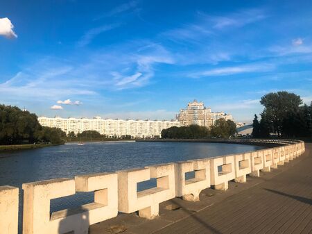 Beautiful view of the river pond in the city center with the promenade against the blue sky and high-rise buildings.の写真素材