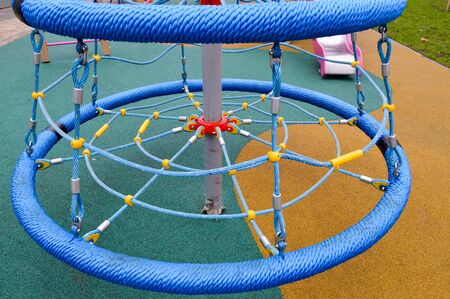 New modern safe outdoor playground in the open air with exercise equipment and toys in a new district of the city in the courtyard of a new building.の写真素材