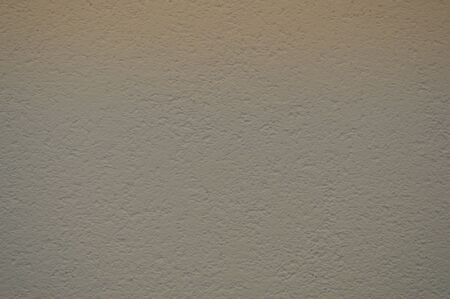 Wall of beige rough embossed building decorative stucco. Texture, background.の写真素材