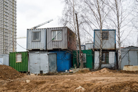 Small temporary houses of builders from containers at an industrial construction site. Block-modular...