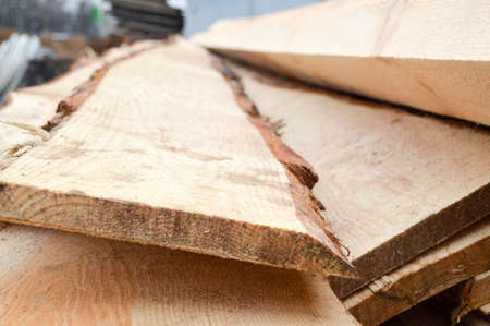 Lots of long wooden natural planed boards and sticks at a sawmill. The background. Texture. Concept: timber harvesting for the wood industry.の写真素材