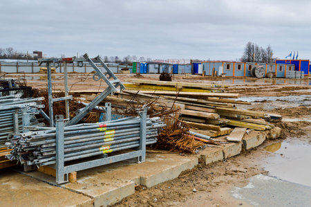 A lot of building materials with metal spare parts, sticks, beams, pipes at an open-air construction...
