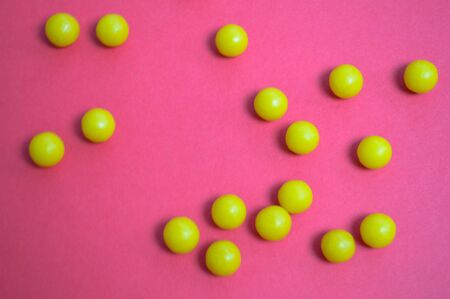 Yellow round medical pharmaceutical drugs for the treatment of diseases and the killing of microbes and viruses pills and vitamins medicines for coronavirus on a pink background.の写真素材