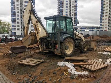 construction machinery is located in the city center in a modern residential complex. a tractor with...
