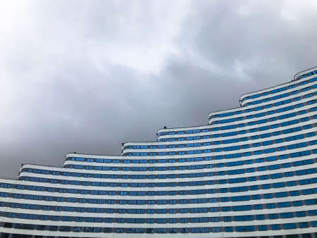 urban landscape against the backdrop of a cloudy sky. house of different heights, with rolls on roof, non-uniform building size.  building in the form of a wave. in the city center in blue and white.の写真素材