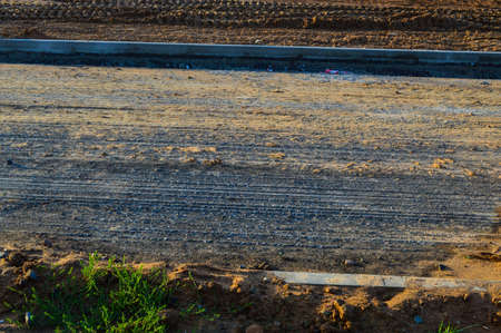 preparation of the road for laying the improved road surface. gravel road to create a new layer of asphalt. construction work in the city center. construction of a road and a bridge.の写真素材