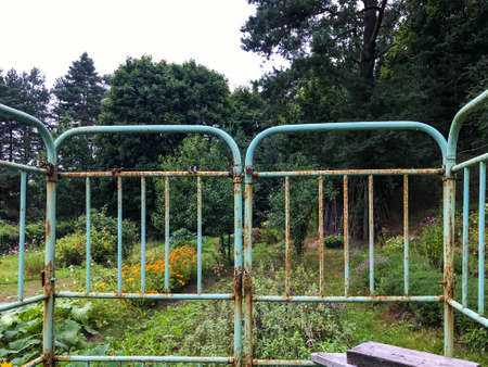 rusty headboards from old beds. homemade fence from scrap materials. metal frames affected by corrosion and rust. homemade hedge.の写真素材
