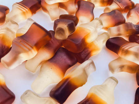 the bottle-shaped marmalade is in a small, round and transparent plate. gelatinous mouth-watering sweets. macro photography. bottles are sweet, scattered on a matte background.の写真素材