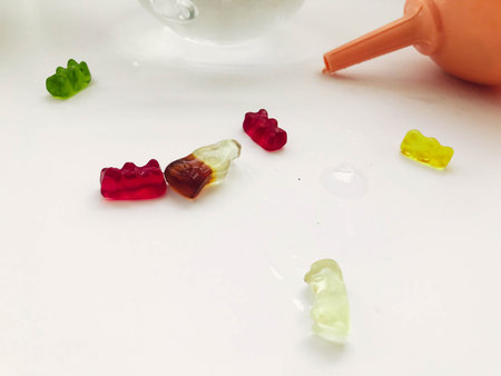 gummy gelatinous bears lie on a wet white matte background. sweet candies are next to the watering...