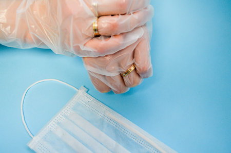 Gold wedding rings on hands in protective medical rubber disposable gloves for protection against...