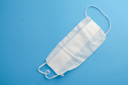 Medical protective masks isolated on blue background. Flat lay. Copy space.の写真素材