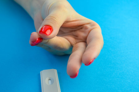 A doctor takes blood sample from the finger of a patient for the testの写真素材