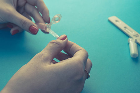 taking blood from a finger. home diagnostics, finger prick with lancet to get blood. capillary...