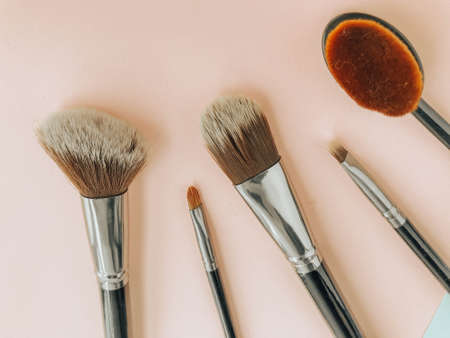 Premium makeup brushes on blue and pink background, creative cosmetics flat lay, tools for make up, copy space.の写真素材