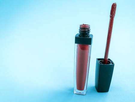 Brush for make-up lips and the bottle of liquid lipstick close-up on a pink background with copyspace.の写真素材
