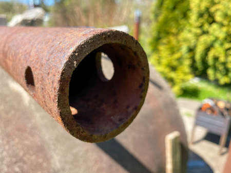 Rusty iron metal industrial pipe of large diameter old with holes for pumping liquid and construction in an oil refinery, petrochemical plant.の写真素材
