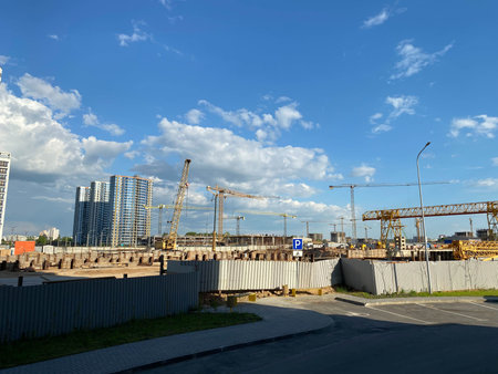 Tall building under construction with scaffolds. Construction site. Hoisting cranes. new...