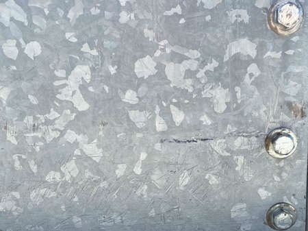 Photo closeup old rusty grunge steel aluminum fragment of protective structure made of metal plates sheets assembled with button head rivets on armor textured background, horizontal picture.の写真素材