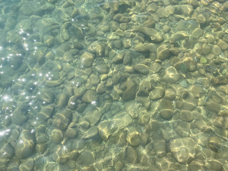 Old big Stones under clear water. Natural background of Stones at the bottom of a lake, river. A...