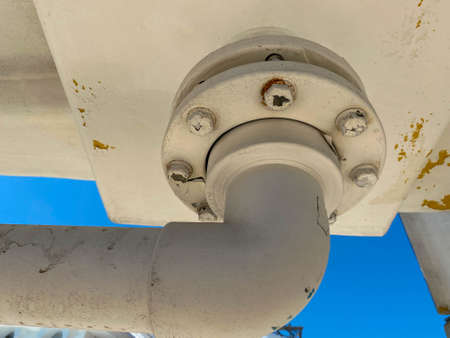 close-up view of the flange with bolts of a heavy metal joint on a pipe that transports liquid to an industrial plant.の写真素材