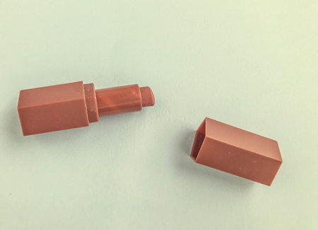 matte lipstick on a blue bright matte background. beige lipstick in the shape of a heart, soft brown...
