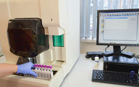 nurse works with biological material. disposable glasses for the material are numbered and signed. PCR research, microbiology. examining material under a microscope.の写真素材