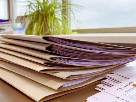 thin folders with sheets of paper inside. brown corton folder for saving documents. storage of office sheets and protocols. paperwork in the office.の写真素材