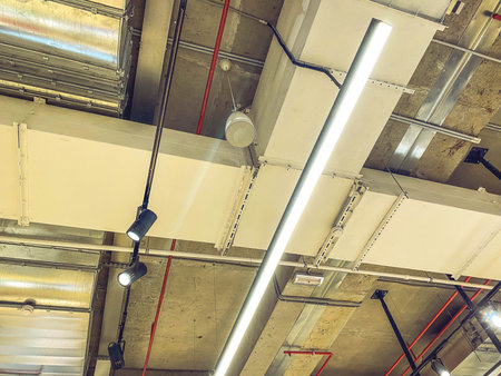 loft style apartment. ceiling in a new building. metal sheet on the roof, long modern and stylish lamps are attached to the ceiling.の写真素材