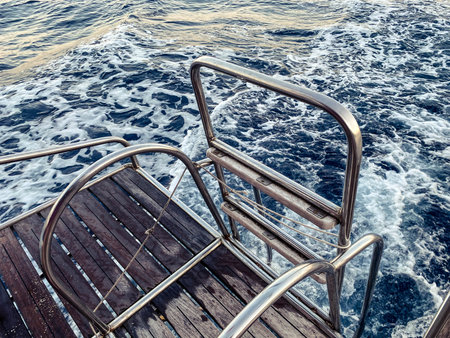 bridge made of wood with metal breaks into the sea. water with waves and white foam. bridge on a yacht for swimming and diving. leisure.の写真素材