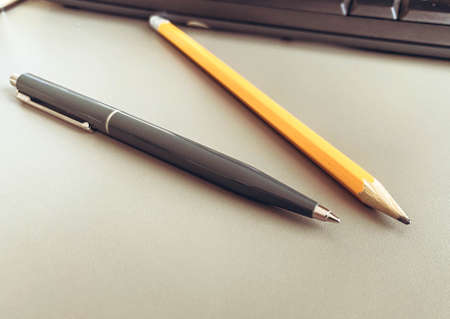 stationery on the table in the office. a blue metal pen for writing, a simple wooden pencil with lead. paper writing tool.の写真素材