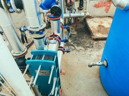 utility room. gray metal structures. on designs of blue valves with red switches. factory building, water treatment.の写真素材