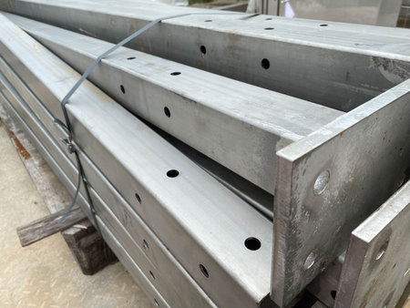 Metal structures for construction and pipes on pallets in an open-air storage warehouse for the...