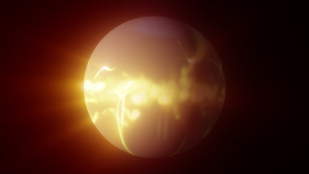 Intense golden energy sphere glowing with bright swirling light waves and warm radiant flares in a dark background.の写真素材