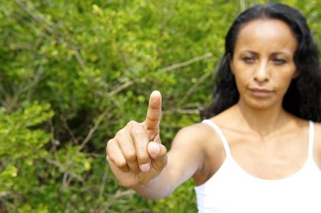 Young latin woman pointing with a finger in the air. の写真素材