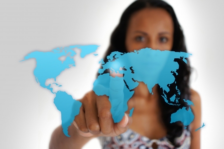 Young latin woman pointing with a finger iof a world map.の写真素材