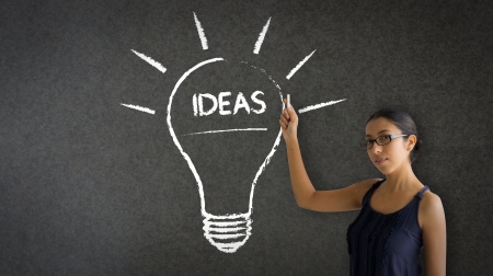 Woman pointing at an ideas lightbulb illustration.の写真素材
