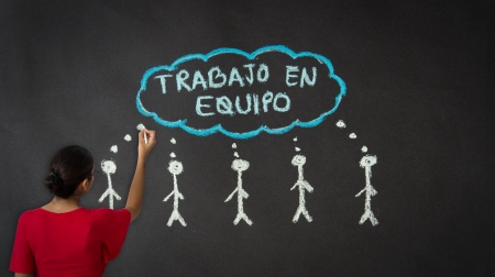 Woman drawing a teamwork diagram with chalk on a blackboard の写真素材