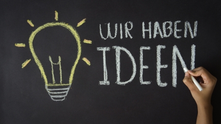 A person pointing with chalk at an We have Ideas illustration. の写真素材