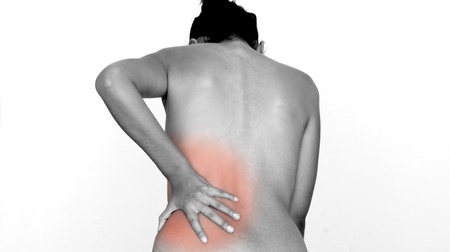 A woman having pain and rubbing her lower back.の写真素材
