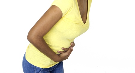 Woman leaning over having stomach cramps.の写真素材