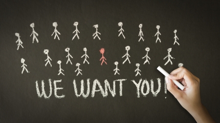 A person drawing and pointing at a We want you chalk drawingの写真素材