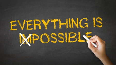 A person drawing and pointing at a Everything is Possible Chalk drawingの写真素材