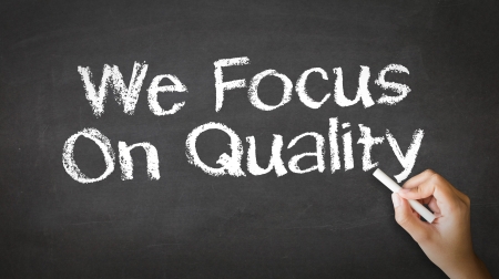 A person drawing and pointing at a We Focus On Quality Chalk Illustrationの写真素材