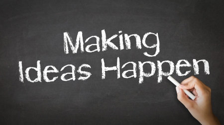 A person drawing and pointing at a Making Ideas Happen Chalk Illustrationの写真素材