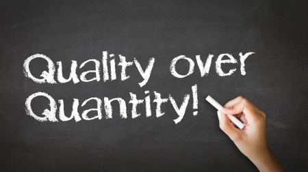 A person drawing and pointing at a Quality over Quantity Chalk Illustrationの写真素材