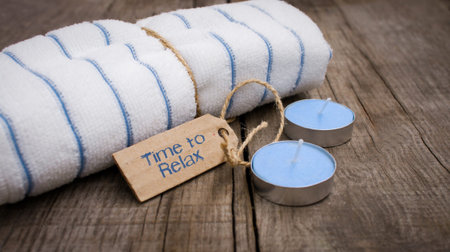 A towel with a sign and candles on wooden backgroundの写真素材