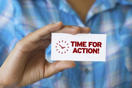 A person holding a white card with the words Time For Actionの写真素材