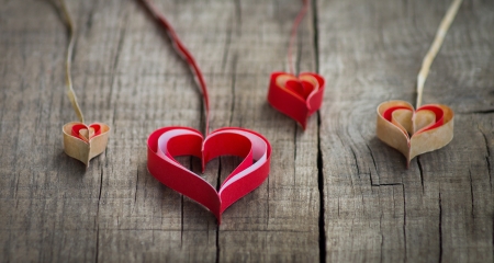 Four Handmade Paper hearts on wooden background.の写真素材