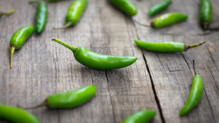 Green Jalapenos chili pepper on wooden backgroundの写真素材