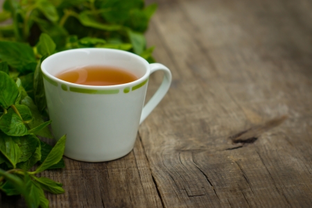A cup of mint tea on wood textured backgroundの写真素材